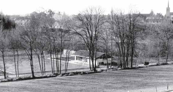 Photographie ancienne en noir et blanc des installations du tennis d’Echallens entourées de champs
