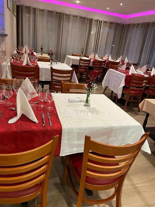 Tables dressées du restaurant en soirée, avec éclairage d’ambiance