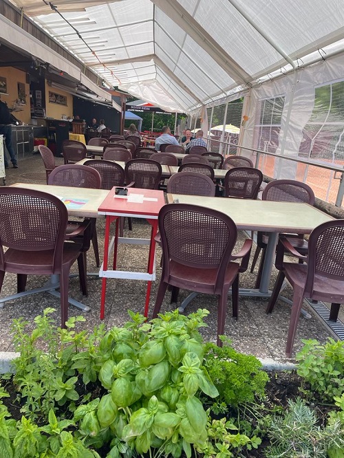Terrasse couverte du Restaurant du Tennis, tables dressées